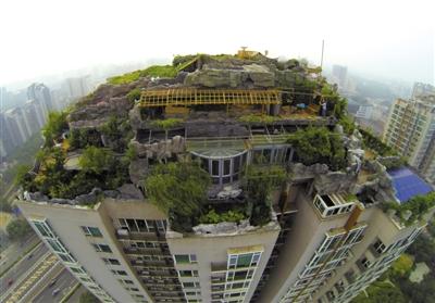 　　昨日，身穿橘黃色馬甲的工作人員在人濟(jì)山莊樓頂拆除違章建筑。新京報(bào)記者 吳江 攝