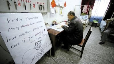 張大爺在門衛(wèi)室里工作，旁邊是紅爆網(wǎng)絡(luò)的溫馨提示牌記者