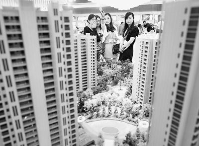 圖為近日，浙江杭州一家房產(chǎn)公司的兩位銷售人員一起向購房者介紹樓盤。新華社記者 王定昶攝