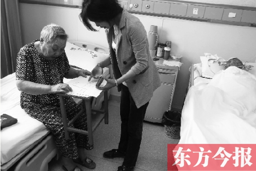 昨日，鄭大五附院二號(hào)樓住院部，馬老太寫下委托書，并簽字摁指印委托女兒代理為昏迷老伴解鎖取錢