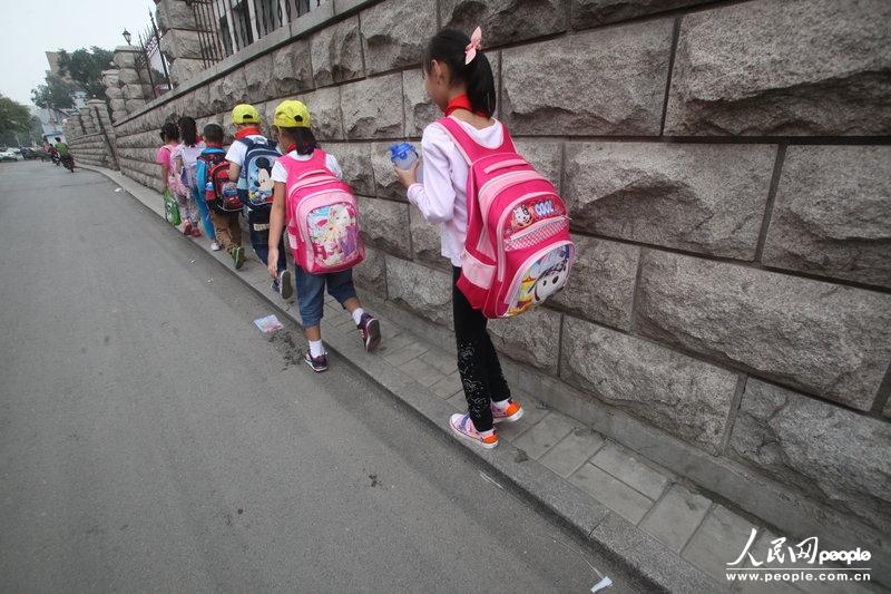 2013年09月11日，濟(jì)南運(yùn)署街上，小學(xué)生走史上“最窄人行道”上學(xué)。