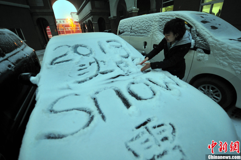 11月18日，行人在車輛的積雪上涂鴉。