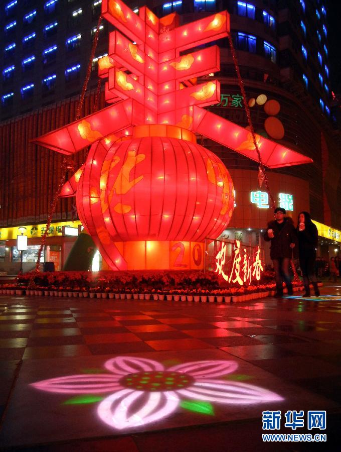 　1月30日晚，市民從蘇州市石路銀河廣場上大型“春”字彩燈景觀旁經(jīng)過。