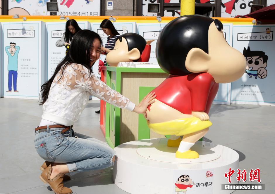 4月22日，游客與蠟筆小新合影。“蠟筆小新25周年紀(jì)念特展”日前在北京開展，吸引了不少市民游客。