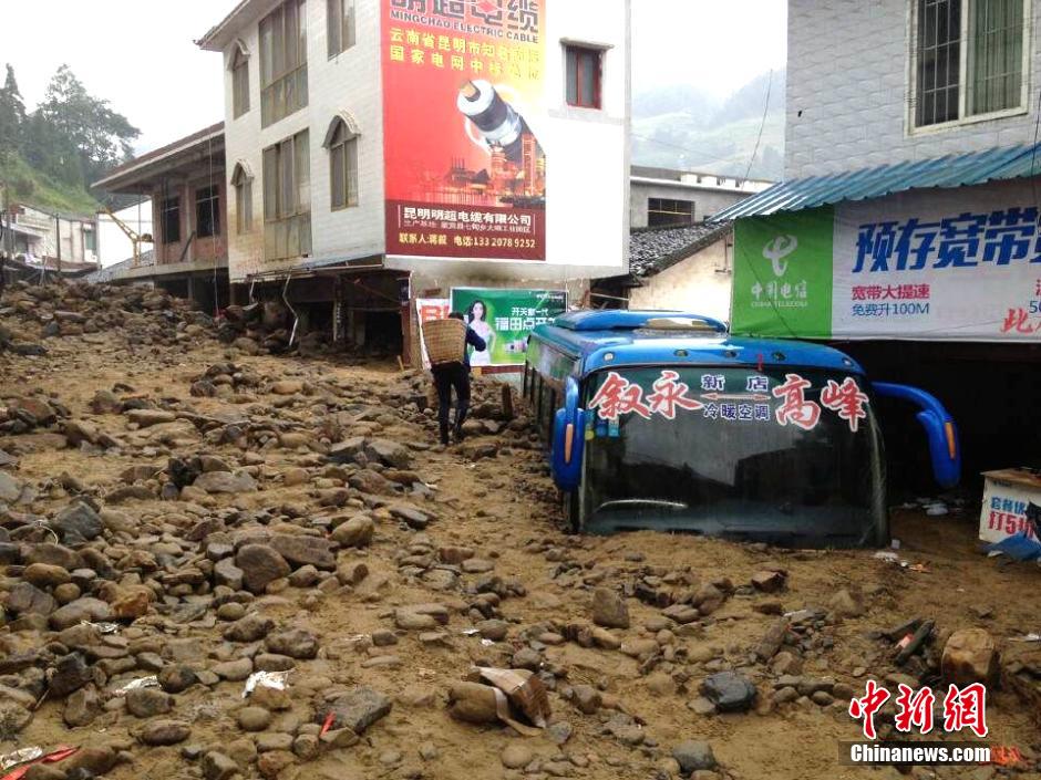 圖為山洪泥石流導(dǎo)沖進鄉(xiāng)鎮(zhèn)街道，導(dǎo)致客車被埋。