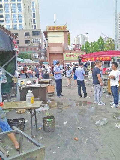 昨天，執(zhí)法人員在京廣路長(zhǎng)江路口整治“僵尸圍擋”及圍擋內(nèi)的攤販。