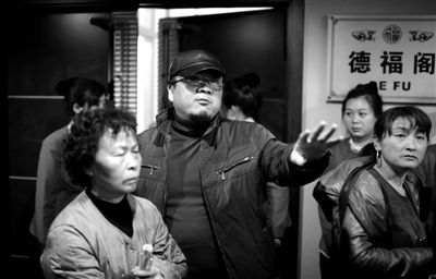 昨日，在河北香河天下第一城，相關(guān)負(fù)責(zé)人（左二）走出會議室與參加演出的老人們溝通。
