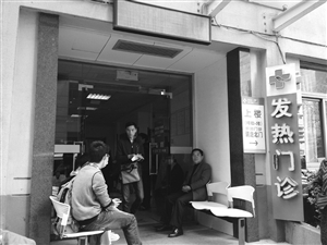 到浙大一院發(fā)熱門診就診的病人增多，不少人在門口等候
