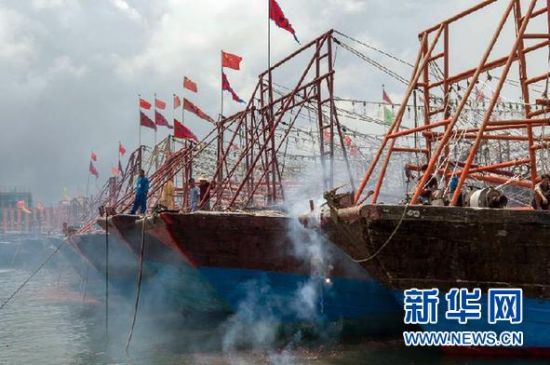 2013年8月1日 南海開漁日 臨高迎新港 8月1日，海南省臨高縣漁民在船上鳴放鞭炮慶祝武蓮港開港。