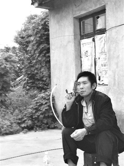 9月12日，陳文才在自己的出租屋旁抽煙。新京報(bào)記者 朱柳笛 攝