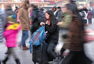 春運(yùn)首日，北京站客流量明顯增多，一名女孩在人流中等待進(jìn)站。