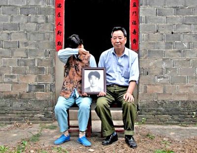 江蘇鎮(zhèn)江，老劉夫婦捧著獨生子的遺像在老家前留影南方都市報供圖L