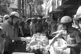 7月11日，瀏陽市北正中路，執(zhí)法人員暫扣張海的水果。這是瀏陽市城管局拍攝的執(zhí)法現(xiàn)場(chǎng)圖。