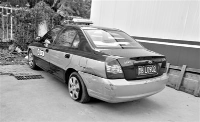 昨日，被撞爆胎的“克隆”出租車，停在朝陽(yáng)交通支隊(duì)奧運(yùn)村大隊(duì)院內(nèi)。新京報(bào)記者 黃月 攝