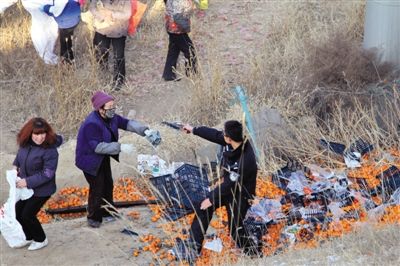 1月4日，連霍高速蘭州市榆中縣和平鎮(zhèn)段，一名警察舉著槍驅(qū)散哄搶橘子的村民。圖/CFP