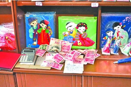 　　2012年6月21日，在朝鮮羅先特別市的一家商店里，柜臺上散落著一些人民幣。在朝鮮，人民幣比本國