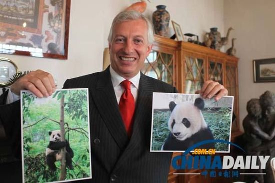 動物園的創(chuàng)始人兼主席埃里克展示熊貓星徽和好好的照片