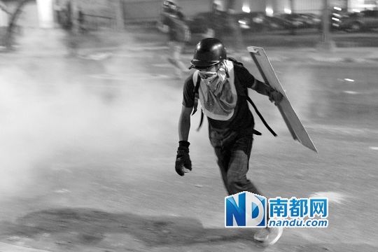 反政府示威者在與警察的沖突中躲避催淚彈。