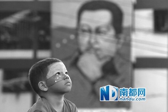 3月5日，一名委內(nèi)瑞拉兒童仰望天空，他身后是查韋斯的陵墓。