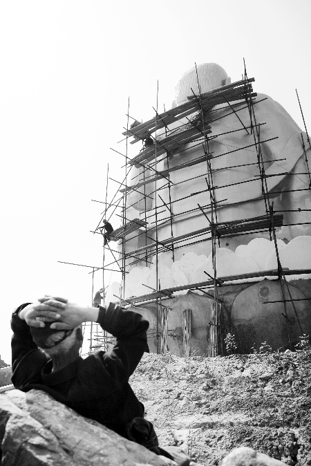 今年4月26日，工作人員將帆布蓋在“佛像”頭像上