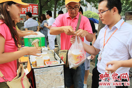 圖為徐貴雨和一名勤工助學(xué)的學(xué)生在街頭義賣快餐。