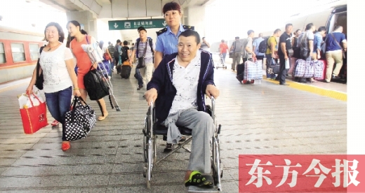 李剛手術(shù)后歸來(lái)，在車(chē)站工作人員幫助下走出鄭州火車(chē)站站臺(tái)  東方今報(bào)首席記者 張曉冬 攝