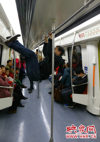 地鐵試乘日，一男子在車廂內(nèi)攀爬扶手自娛自樂