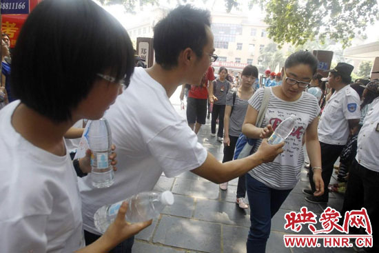 志愿者為剛剛考試完的考生送上1瓶冰凍的冰露·純悅，消暑解渴為考生加油