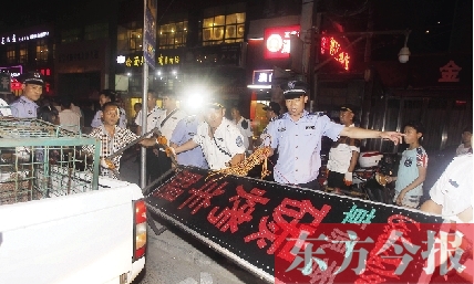 7月8日晚，鄭州市商城路一家占道經(jīng)營(yíng)的攤販招牌被執(zhí)法隊(duì)員“登記保存”