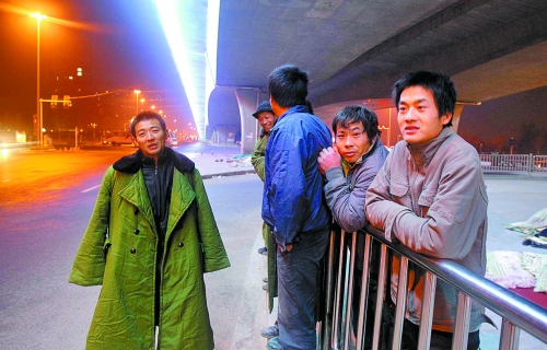 冬夜里，農(nóng)民工在橋下等著干活兒。