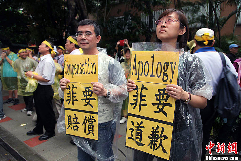 　圖為當(dāng)天下午，當(dāng)臺灣數(shù)百漁民在馬尼拉經(jīng)濟(jì)文化辦事處前抗議時，有兩名年輕人手持標(biāo)語，在路邊聲援。中新