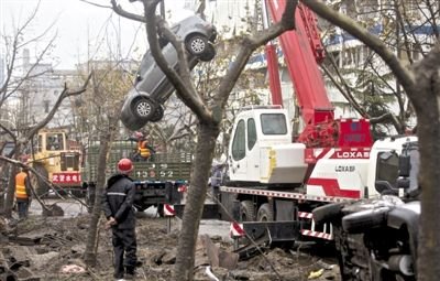 輸油管道爆炸后，搶修人員將被炸毀的車輛運出現(xiàn)場。