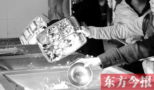 11月27日，河南中醫(yī)學(xué)院餐廳，一名同學(xué)將餐盤內(nèi)沒吃完的食物倒入餐具回收車內(nèi)