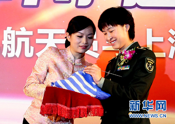 11月1日，航天員劉洋（右）在為“愛(ài)心”毛衣編織最后的收尾針。
