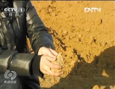 麻剛沙系麻剛石粉碎而成。記者找到一塊麻剛石，一捏就碎成粉末，硬度非常差。央視截圖