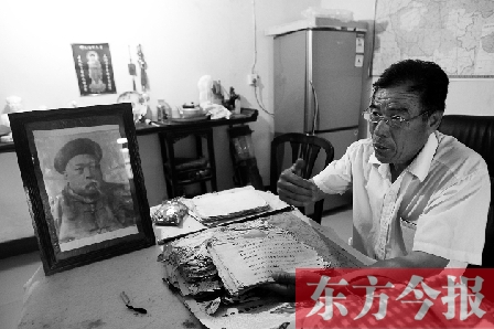 　魏樹紹手拿《物權(quán)法講義》手稿，在講訴先祖書寫“物權(quán)法”的歷史（相框里就是魏聯(lián)奎）