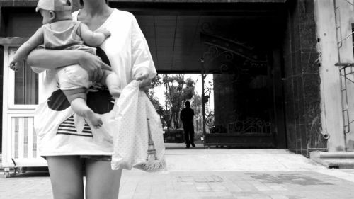 抱著孩子出售人奶的女子。