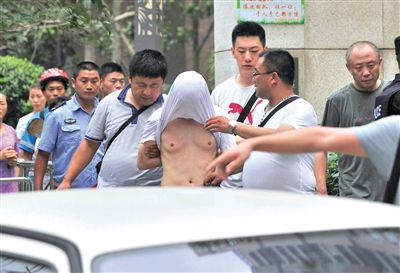 昨日，成都警方抓捕時與毒犯發(fā)生槍戰(zhàn)。一名男犯罪嫌疑人被警方押出。