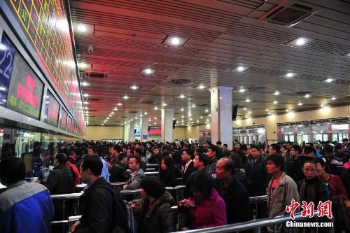 資料圖：12月25日，2014春運(yùn)臨客車票在廣州火車站開售，購(gòu)票市民在售票窗口前排起長(zhǎng)隊(duì)。中新社發(fā) 陳驥旻 攝
