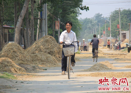 圖為王格現(xiàn)騎著自行車去學(xué)校。