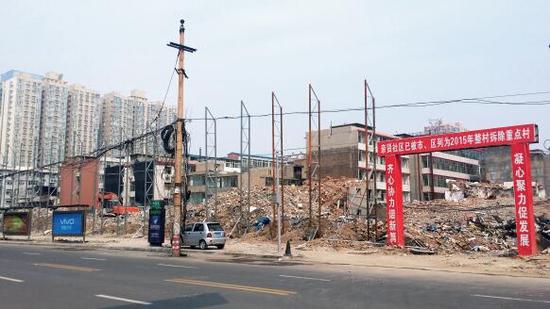 015年5月31日，在社區(qū)干部的帶頭拆遷下，親賢社區(qū)的“城中村改造”拉開帷幕。由于前期“清產(chǎn)核資”及補(bǔ)償標(biāo)準(zhǔn)等因素，拆遷改造工作推進(jìn)并不順利。圖為位于體育西路東側(cè)集體所有的商鋪率先被拆遷完畢，用于遮擋的圍擋正在施工中。（拍攝：2015年9月16日）