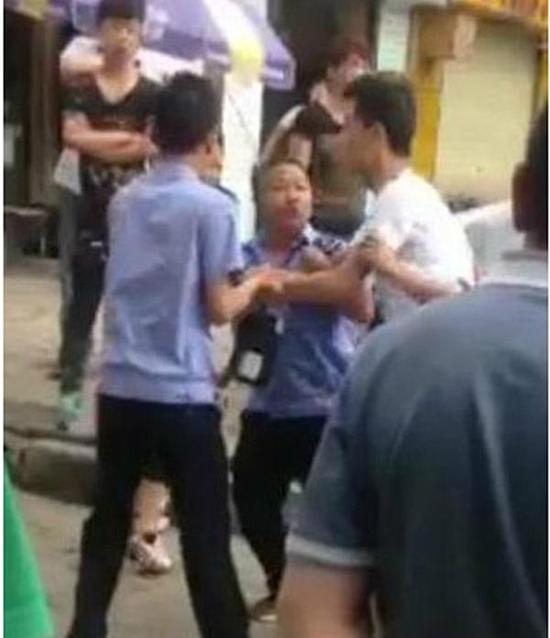 付某（右）與城管執(zhí)法人員廝打在一起。