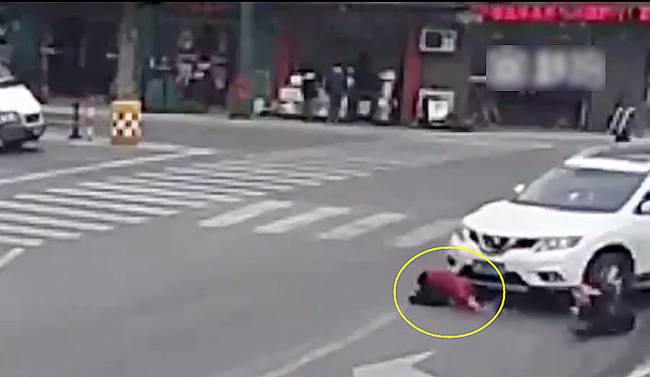 圖為小姑娘被卷進(jìn)車輪下瞬間。