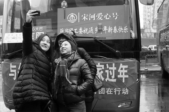 昨天上午8時(shí)，鄭州正道中環(huán)百貨廣場，準(zhǔn)備回家的老鄉(xiāng)在愛心大巴車前合影留念