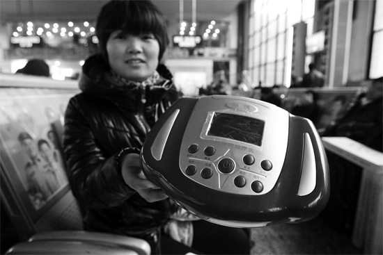 火車站候車室，李女士向記者展示她準(zhǔn)備孝敬父母的按摩儀