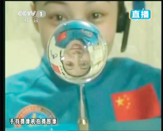 王亞平的倒影出現(xiàn)在水球中。新華社發(fā)（視頻截圖）