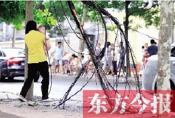被雷電擊斷的高壓線(xiàn)和通訊電纜垂在地面上