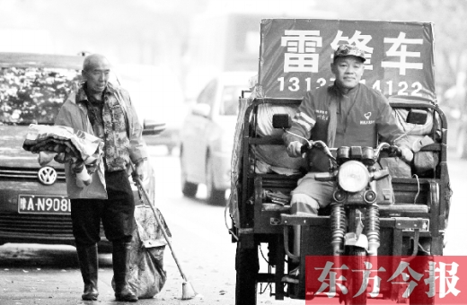 鄭州市商城路，一名環(huán)衛(wèi)工懷抱著剛剛收到的毯子，目送“雷鋒哥”孫德坤離開