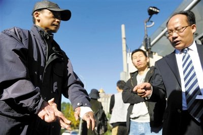 常林鋒在法院外展示雙手，他稱被燙傷的手因刑訊逼供且未得到及時(shí)救治