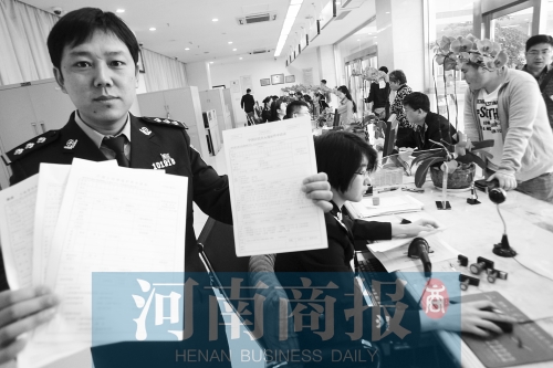 　民警左手拿的是新申請表，右手拿的是三份老申請表 王春勝/攝